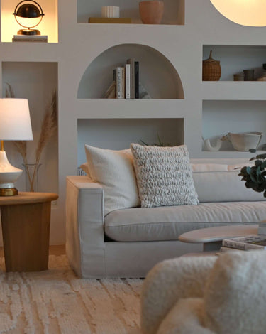 Oliver rechargeable lamp in ivory and brass on a side table in a living room