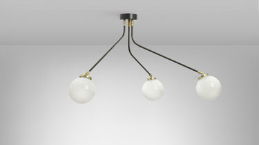 Array Mini pendant in bronze with three opal glass globes on rotating arms, studio view