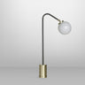 Array table lamp in bronze with a rotating arm and a shiny opal glass globe, studio view