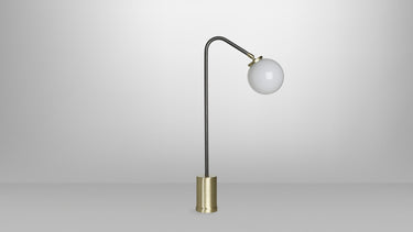 Array table lamp in bronze with a rotating arm and a shiny opal glass globe, studio view