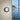 Oluce Berlin-Out black round wall lamp on a pale wall beside a window with a sea view