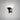 Torres wall light in bronze with a funnelled metal shade angled upward on a grey studio wall