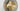 Close-up of the brass disc and smoked glass shade of the Pendulum floor lamp, lit