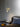 Heron wall light with a cylindrical shade on a short arm, in a room setting