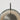 Close-up of the bronze disc and smoked glass shade of the Pendulum floor lamp