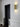 Ring wall light in brass on a white wall beside a dark door