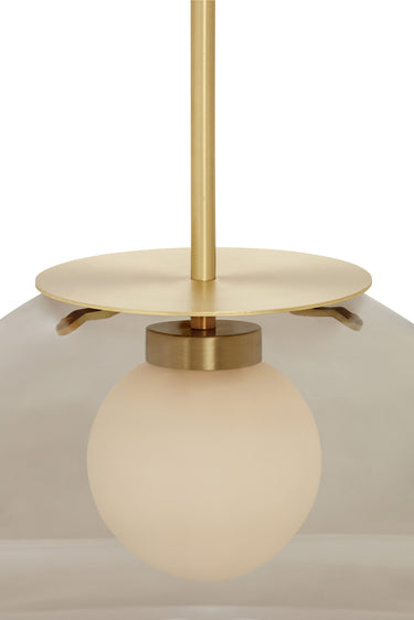 Close-up of the Petra pendant in satin brass with a matt opal inner shade