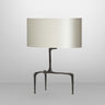Braque table lamp in bronze with a hand-cast three-legged base and an oval dove grey shade, studio view