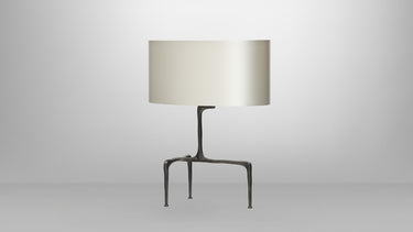Braque table lamp in bronze with a hand-cast three-legged base and an oval dove grey shade, studio view