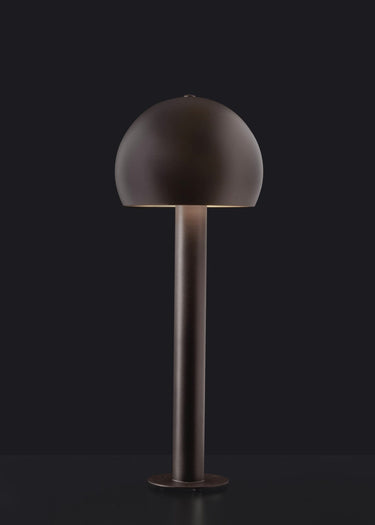 Oluce Otto outdoor floor lamp in Indian brown metal with a dome head on a dark studio background