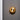 Pendulum wall light with a satin brass disc on a dark wall