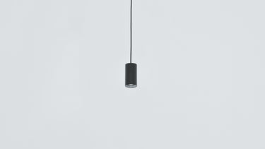 Black Anvil Spot S spot pendant hanging against a pale wall