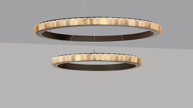 Avalon Halo chandelier, two rings of honed alabaster cylinders in a bronze frame, lit, studio view