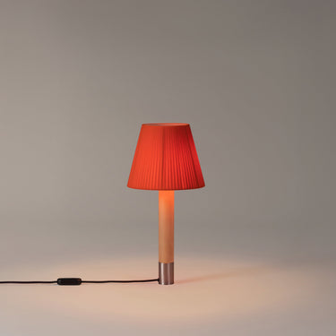 Elegant Basica M1 bedside table lamp by Santa & Cole with soft ambient illumination, Red-Amber Ribbon Shade