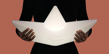 Goodnight Light The Boat Lamp floating in a swimming pool at night with a star-shaped reflection.