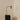 Heron table lamp with a slim stem and a cylindrical shade, in a room setting