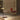 Brass Tinto pendants hanging over a table beside a leather chair in a warm paneled room