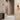 Gaia wall lights in bronze with smoked glass on a plaster wall beside a stair, shown with the short version