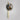 Tall Gaia wall light in satin brass with a hand-formed smoked glass globe, shade facing up
