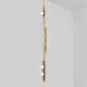Modulo Vertical pendant light in satin brass, studio view