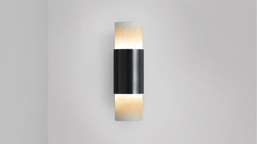 Short Roma wall light in bronze with alabaster at both ends, lit, studio view