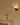 Close-up of a Relic wall light with a veined alabaster shade above a vase on a stone mantel