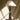 Cubist table lamp on a black plinth against a draped backdrop with window light and its cord