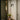 Heron wall light with a cylindrical shade on a short arm, in a room setting