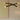 Trace Linear X chandelier with two crossing bronze strands above a round dark table in front of a pale artwork