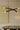 Trace Linear X chandelier with two crossing bronze strands above a round dark table in front of a pale artwork
