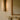 Contour wall light with textured glass beside a mirror above a fireplace