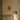 Heron wall light with a cylindrical shade on a short arm, in a room setting