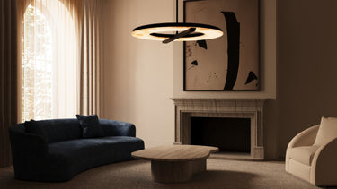 Ceres pendant with an alabaster ring hanging in a living room with a dark blue sofa and a fireplace