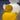 The compact size of the small Duck Yellow and White Duck Lamp by Goodnight Light shown next to a book on a nightstand for scale.