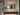 ET2 Latitudes slim oval bath sconce in Black glowing above a bathroom mirror and floating wood vanity
