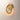 ET2 Lyra gold ring wall sconce lit, seen from the side on a cream wall