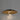 Black and brass pendant light illuminating a dining room table