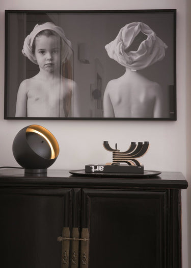 Eva LED table lamp by Oluce in black metal with gold interior, modern indirect lighting design for bedroom bedside table