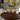 ET2 Flute tube cluster over an oval dining table with gray upholstered chairs and colorful wall art