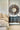 ET2 Flute tubes beside a bed with a round sunburst mirror and a dark console