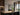 ET2 Hover single long black baton pendant over a kitchen island with a view of trees