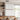 ET2 Joist wood-frame linear pendant hanging over a dining table in front of a tall window and open shelving
