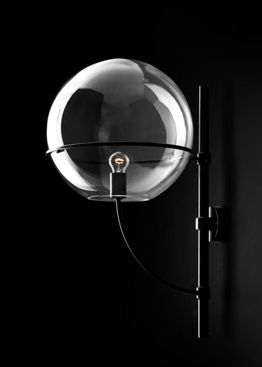Lyndon outdoor wall lamp by Oluce in black with a transparent globe, studio shot