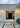 Lyndon outdoor wall lamp by Oluce flanking a front entry, lifestyle view