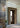 Lyndon 161 mini outdoor wall lamp by Oluce beside a glass-block doorway, lifestyle view