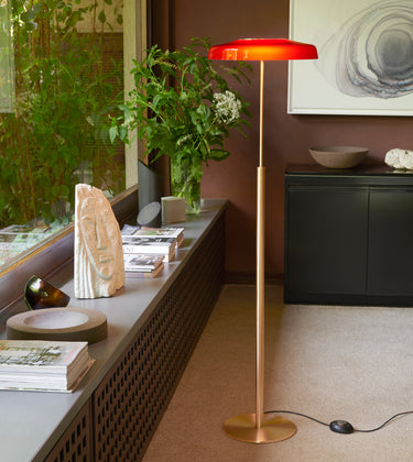 Oluce Dora floor lamp in satin gold with red glass shade, studio shot