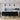ET2 Mermaid black and gold cone pendants in a row over a white kitchen island with black bar stools