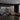 ET2 Nodes ring pendant over a dining table in a dark room with a slatted wood wall