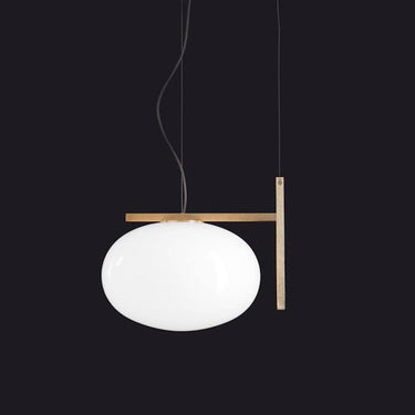 Oluce Alba 466 pendant light in satin brass with a blown glass sphere on a studio background