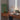 Mustard yellow Oluce Calamaio desk lamp on a walnut desk beside a window